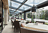 Restaurant dining area with glass ceiling and glass outside wall