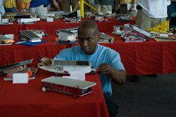 Photograph of judge closely inspecting JSS model car.