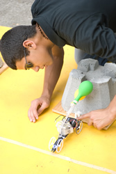 Photograph of students racing putting the model fuel-cell car on the starting line.