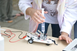 Photograph of students racing fueling the model fuel-cell car.