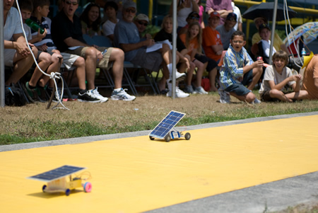 Photograph of two solar model cars racing.