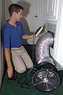 photo of FSEC researcher, Eric Martin, duct testing at air conditioning return.