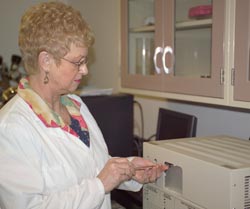 photo of Darlene Slattery injecting hydrogen sample into gas chromatograph equipment
