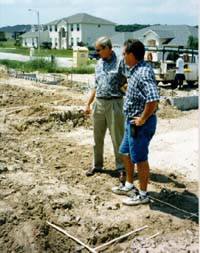Picture of two men looking at ground.
